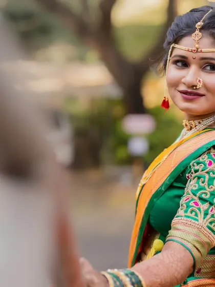 A lovely over-the-shoulder shot capturing the bride's complete look. Her hair is styled in a traditional updo, and the makeup is set to last throughout the long day of ceremonies.