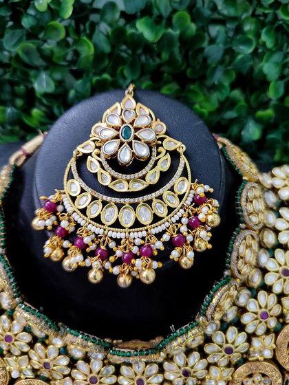 The maang tikka for this set, featuring a crescent shape and delicate floral kundan work.