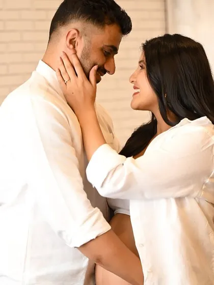 An intimate close-up of an expecting couple, capturing a gentle touch and a loving gaze during their maternity photoshoot.