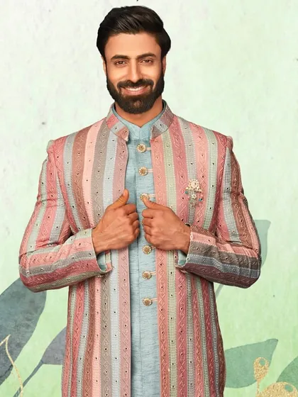A closer look at the unique pastel-striped sherwani. The subtle embellishments and brooch add a touch of sparkle to this modern design.