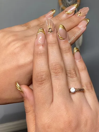 The final look of the gold-wrapped nails, showcasing the full, glamorous set.