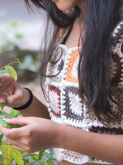 A lifestyle shot of my granny square top, showing how it looks and feels in a natural setting. It's a comfortable and stylish piece of wearable art.
