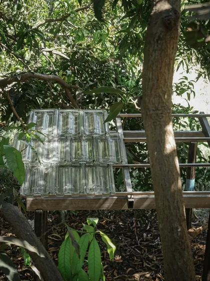 A mock-up of a glass block wall, set up in the shade of a mango tree. This helps us understand the level of transparency and texture the final wall will have.