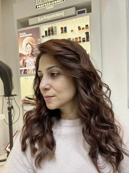 A side profile of the warm chestnut brown color, showing how the curls catch the light and highlight the rich, reddish-brown undertones.