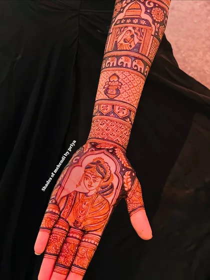 A full-hand view of a bridal design, featuring a bride's portrait on the palm. The arm continues the story with various scenes from the wedding celebrations.