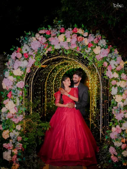 A magical night shoot under a floral archway lit with fairy lights. The bride's magnificent red ball gown makes this a truly show-stopping pre-wedding photo.