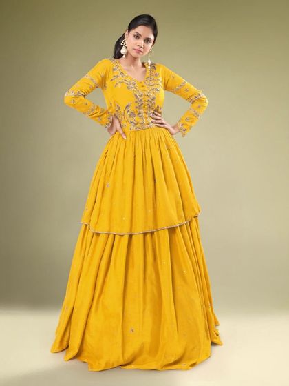 A full look at the yellow tiered Indo-western outfit. The layered skirt adds a fun and modern element to the traditional silhouette.