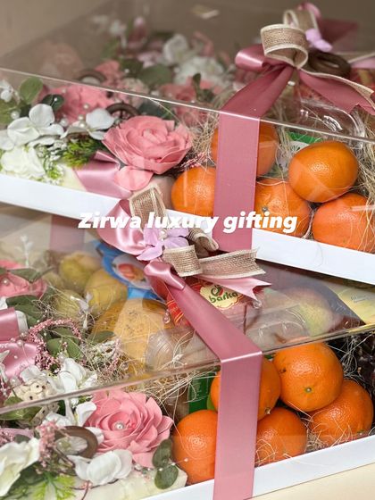 A healthy yet beautiful option for wedding gifting. These acrylic boxes are filled with fresh fruits and decorated with pink floral arrangements.