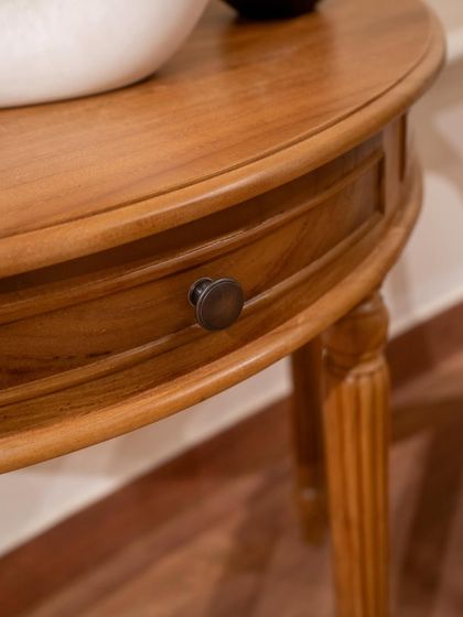 A close-up of the custom-made console table, highlighting the drawer detail with a classic knob and the beautifully carved legs.