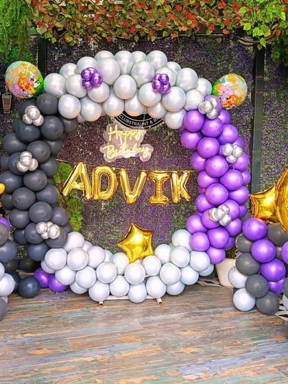 A jungle-themed 6th birthday party. The decoration includes a balloon ring in grey, white, and purple with animal foil balloons and a large foil number '6'.