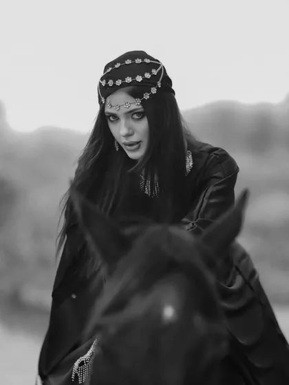 A stunning black and white portrait of a model in elaborate headwear, seated on a horse. This demonstrates how our venue can be transformed to fit a high-concept, artistic theme.