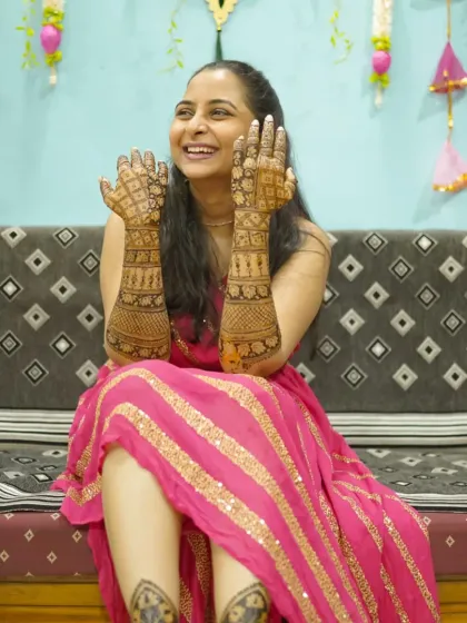 A joyful bride showing off her full bridal mehndi. Her smile says it all. Making my clients this happy is the best part of my job.
