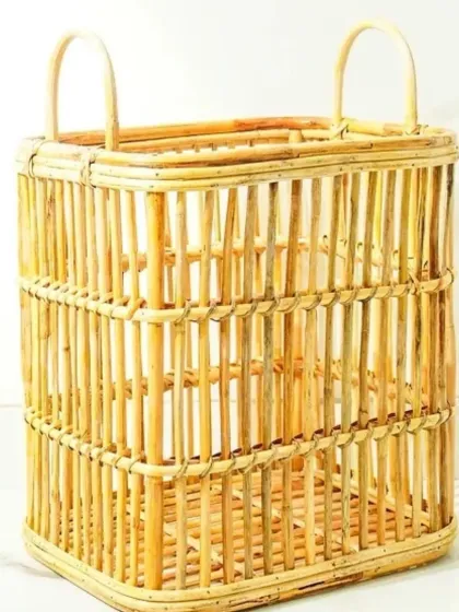 A rectangular, open-weave rattan basket with high handles. This lightweight and airy design is perfect for use as a laundry hamper, a storage basket for towels, or for carrying items around the home.