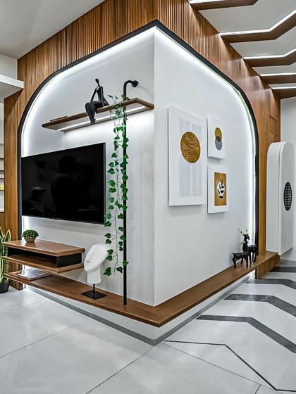 An unconventional corner TV unit design that makes a bold architectural statement. The curved wall, wrapped in wood paneling, creates a unique and dynamic focal point in this modern living room.
