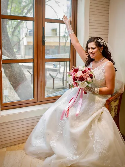 A joyful, candid moment by the window. Her happiness is palpable, and her makeup is fresh and glowing.