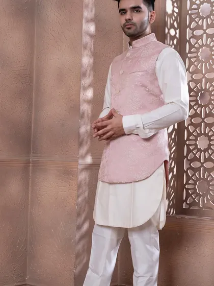 The rose pink bundi set, shown against a textured backdrop. The soft pastel tone is ideal for daytime celebrations and summer weddings, offering a sophisticated and stylish option.