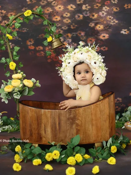 A thoughtful pose from the floral bath session, showcasing the elaborate flower bonnet and charming setup.
