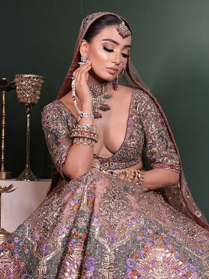 A full view of the bride seated gracefully, showcasing the grandeur of her embroidered lehenga and our multi-coloured polki jewellery set.