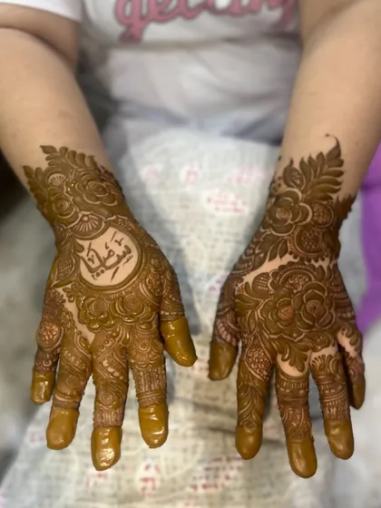 A full view of the design with the Arabic name 'Sumayya' as the centerpiece on one hand.