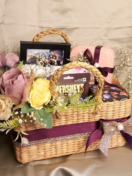 A basket of love, perfect for any couple. This tiered wicker basket is filled with a photo frame, jewelry boxes, and chocolates, making it a wonderful gift for a wedding or anniversary.