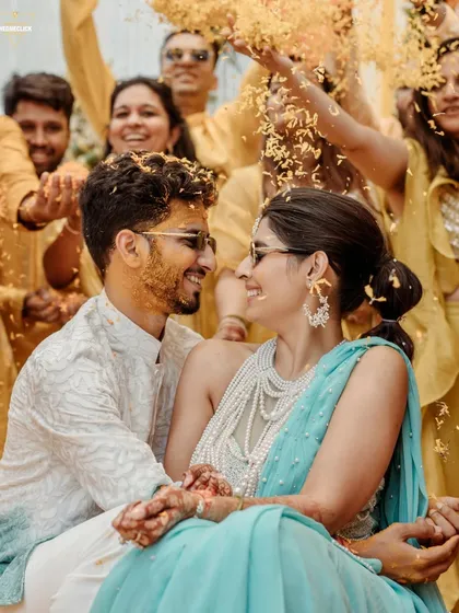 The Haldi is all about unrestrained joy. We get right in the middle of the fun to capture candid moments like this, full of laughter, love, and a shower of petals, preserving the vibrant energy of pre-wedding festivities.