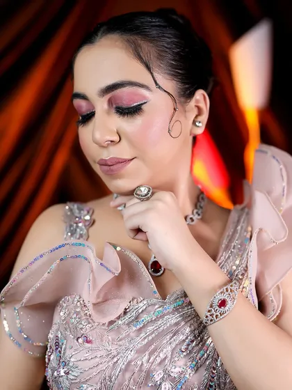 A close-up of the high-fashion makeup, featuring a creative winged liner and a blend of pink and silver on the eyes, perfect for an editorial or reception look.