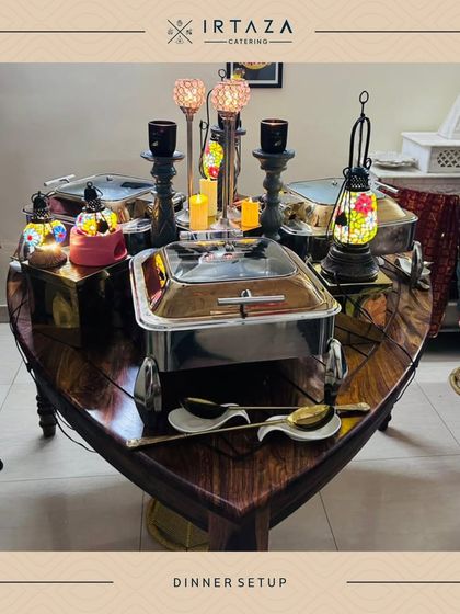 A unique boat-shaped table used for a dinner setup, adorned with colorful lanterns and our signature serveware, showing our creative approach to event styling.