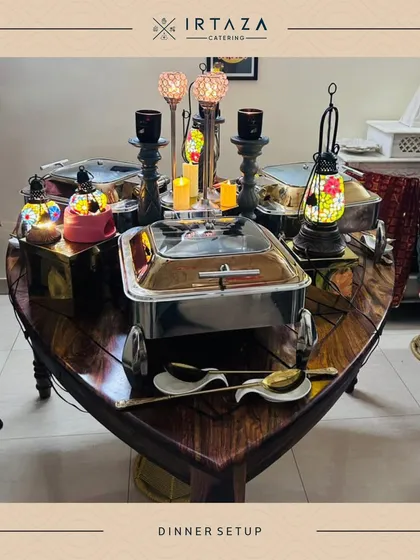 A unique boat-shaped table used for a home catering event. This creative setup, adorned with lanterns and my best serveware, shows how I can work with clients to create a truly personalized experience.