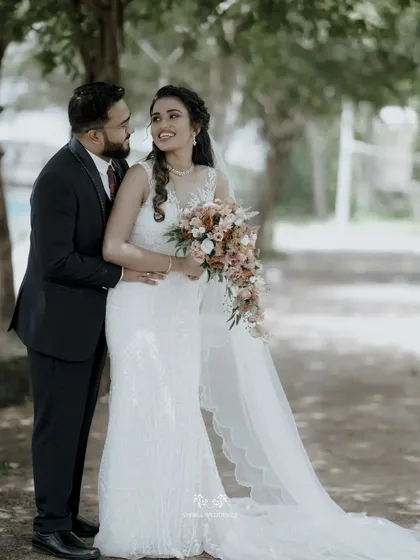 A classic portrait of the bride and groom, their happiness evident as they embrace in a beautiful garden setting.