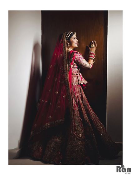 A beautiful portrait of the bride from the back, looking over her shoulder with a smile. The dramatic lighting adds a touch of glamour to the shot.