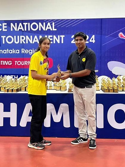 A young female shooter from our academy receives her award, marking another milestone in her competitive journey.