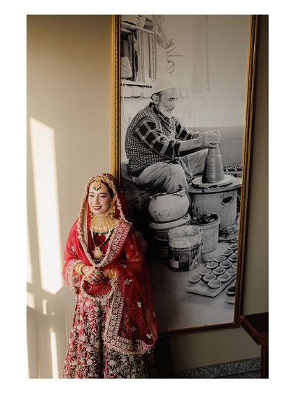 The bride poses next to a piece of art, creating a beautiful composition that blends tradition with contemporary style.