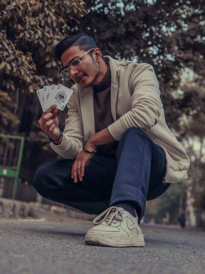 "It's not luck, it's magic. Believe it." A stylish shot in the street, holding the four aces, a symbol of mastery and skill.