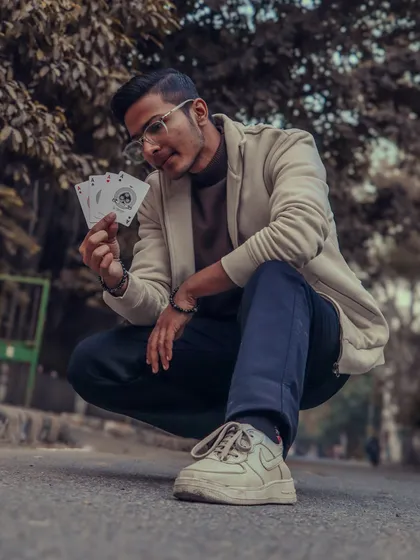 "It's not luck, it's magic. Believe it." A stylish shot in the street, holding the four aces, a symbol of mastery and skill.
