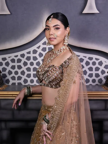 This full view shows how a polished low bun provides a sophisticated foundation for a heavy dupatta and elaborate bridal jewelry, ensuring a regal and put-together look.