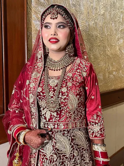 A classic bridal portrait. This bride is wearing a beautiful velvet maroon outfit, and we paired it with a timeless red lip and shimmery eyes for a regal finish.