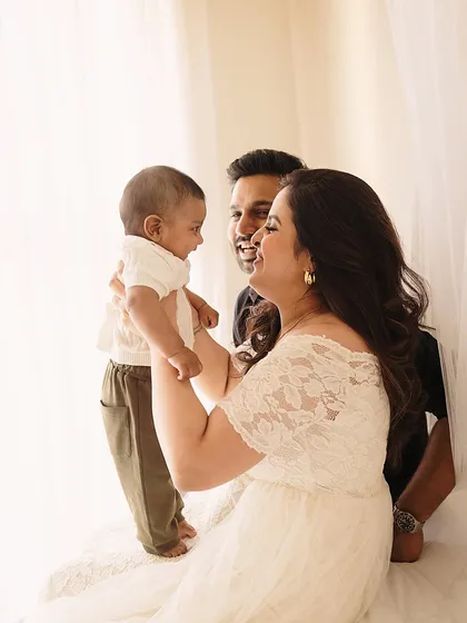 A family of three shares a moment of connection. The soft lighting and gentle interaction make this a perfect example of a lifestyle family portrait.