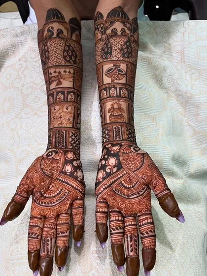 A classic bridal design featuring peacocks and various traditional symbols in separate blocks along the arm. This style is both organized and ornate.