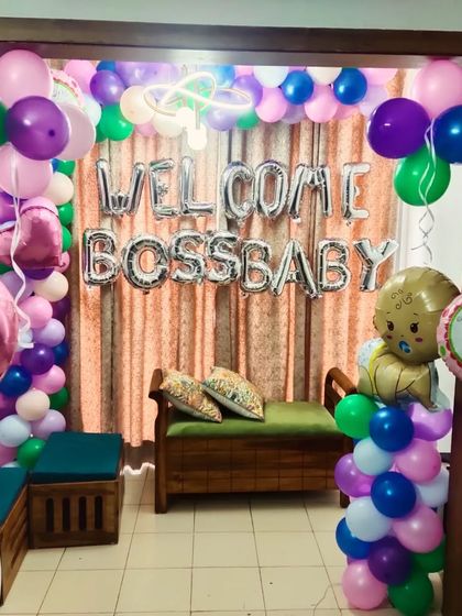 A fun 'Welcome Boss Baby' decoration for a newborn. This colorful setup includes a balloon arch and themed foil balloons.