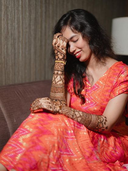 A candid, happy moment of the bride, her hand gently brushing her face.
