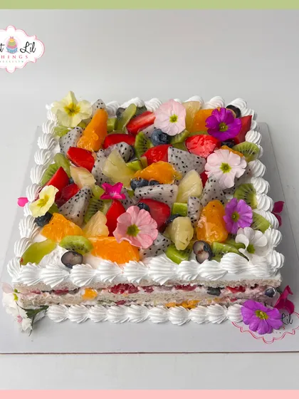 A fresh and fruity cake perfect for any celebration. This square cake is generously topped with a colorful assortment of fresh fruits and edible flowers.