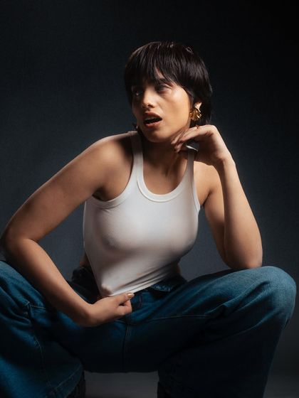 An expressive, dynamic pose captured in the studio. The lighting and the model's candid expression give this shot a sense of energy and spontaneity.