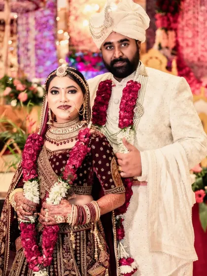 A classic posed portrait of the newly married couple. They stand together, showcasing their beautiful wedding attire and the formal elegance of the occasion. This is a must-have shot for any wedding album.