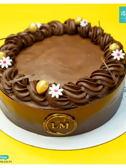 Our Chocolate Hazelnut Praline cake is pure decadence. A smooth chocolate finish is complemented by a piped border, delicate sugar flowers, and crunchy hazelnut accents.