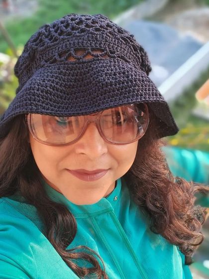 Our crochet hats aren't just for winter. This stylish black bucket hat, modeled by me, is perfect for sunny days in any season, adding a touch of handmade elegance to your look.