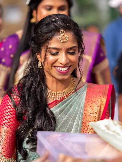 A candid moment of laughter. The bride's makeup is fresh and radiant, perfect for capturing such a happy memory.