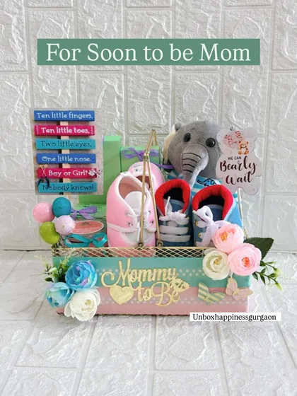 This "For Soon to be Mom" hamper is a popular choice for baby showers. It combines practical gifts like booties with sentimental items like the decorative sign and a soft plush toy.