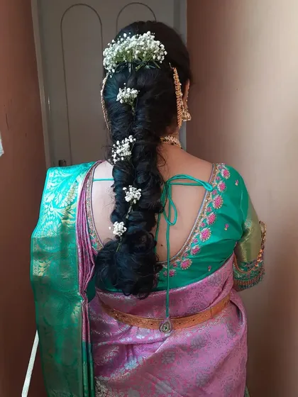 A stunning messy braid intertwined with fresh baby's breath. This hairstyle is perfect for housewarmings, engagements, and receptions.