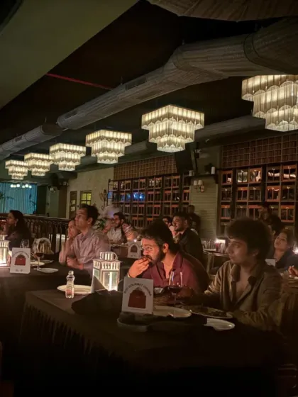 A candid moment from our ZNMD night in Mumbai. The focus is on the screen, but the tables are set for a culinary journey, with wine and the first course ready, showing how we seamlessly blend dining with viewing.