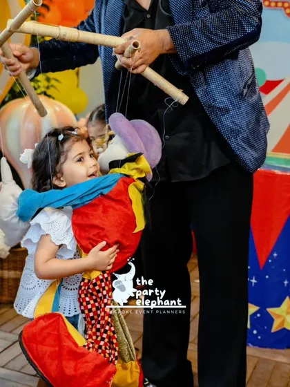 The joy on this little girl's face as she hugs a puppet says it all. We arrange for professional entertainers, like this engaging puppeteer, to captivate young audiences and fill the party with laughter and wonder.